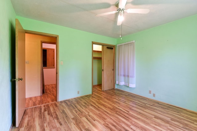 unfurnished bedroom featuring a closet, light hardwood / wood-style floors, and ceiling fan