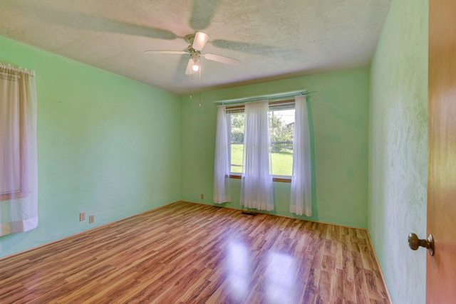 spare room with ceiling fan, a textured ceiling, and light hardwood / wood-style flooring