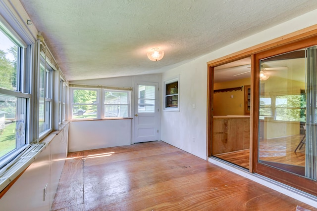 unfurnished sunroom featuring vaulted ceiling