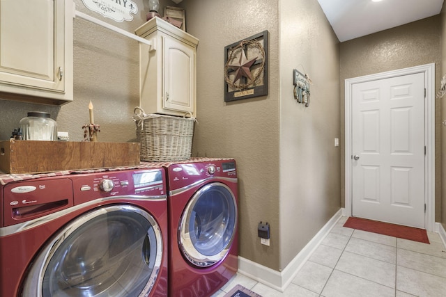 laundry area featuring separate washer and dryer, cabinets, and light tile patterned floors