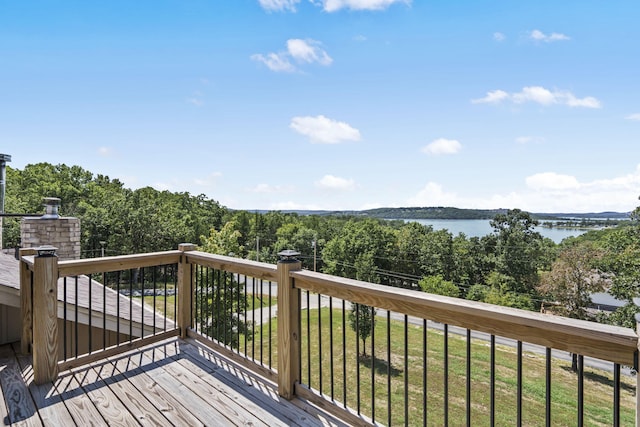 deck with a water view and a lawn