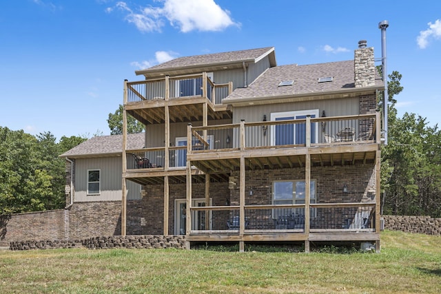 back of house featuring a balcony, a lawn, and a deck