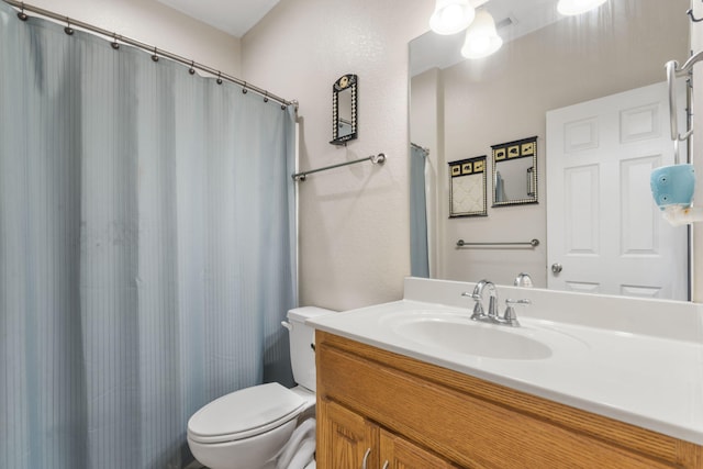 bathroom featuring vanity, toilet, and curtained shower