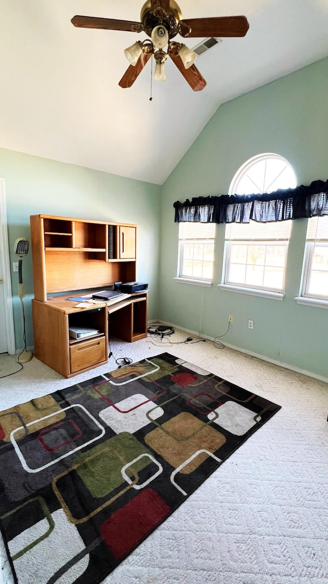 interior space with ceiling fan, vaulted ceiling, carpet flooring, and a healthy amount of sunlight