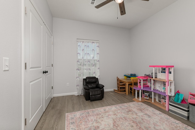 recreation room featuring light hardwood / wood-style floors and ceiling fan