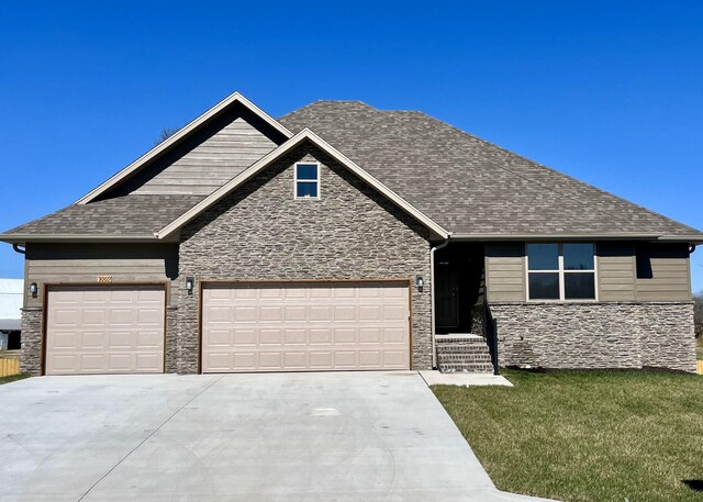 craftsman inspired home featuring concrete driveway, stone siding, roof with shingles, a front yard, and a garage