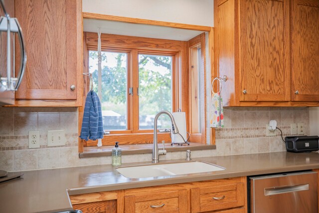 kitchen with tasteful backsplash, appliances with stainless steel finishes, and sink