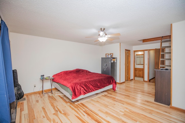 bedroom featuring a textured ceiling, ceiling fan, and light hardwood / wood-style flooring