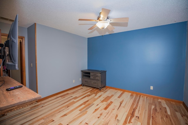 unfurnished bedroom with light hardwood / wood-style floors, a textured ceiling, and ceiling fan