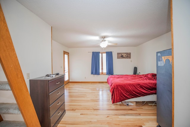 bedroom featuring a textured ceiling, light wood-type flooring, and ceiling fan