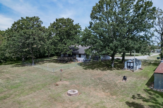 view of yard featuring an outdoor fire pit and a storage unit