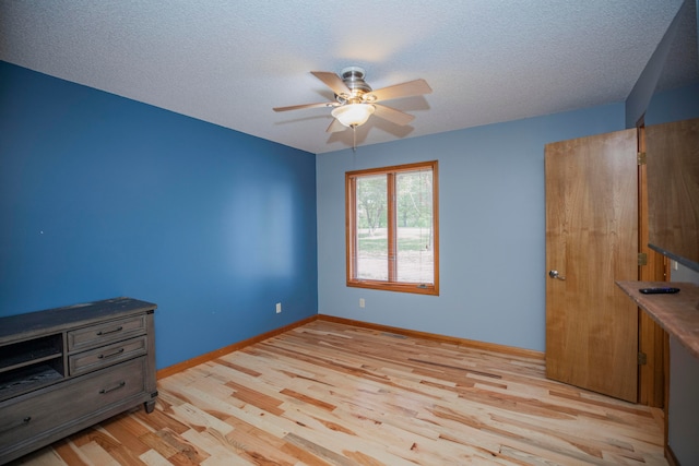 unfurnished bedroom featuring light wood-type flooring, ceiling fan, and a textured ceiling