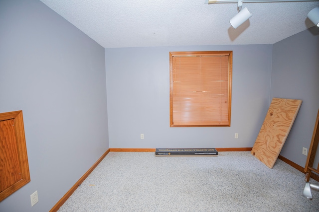 carpeted empty room with a textured ceiling