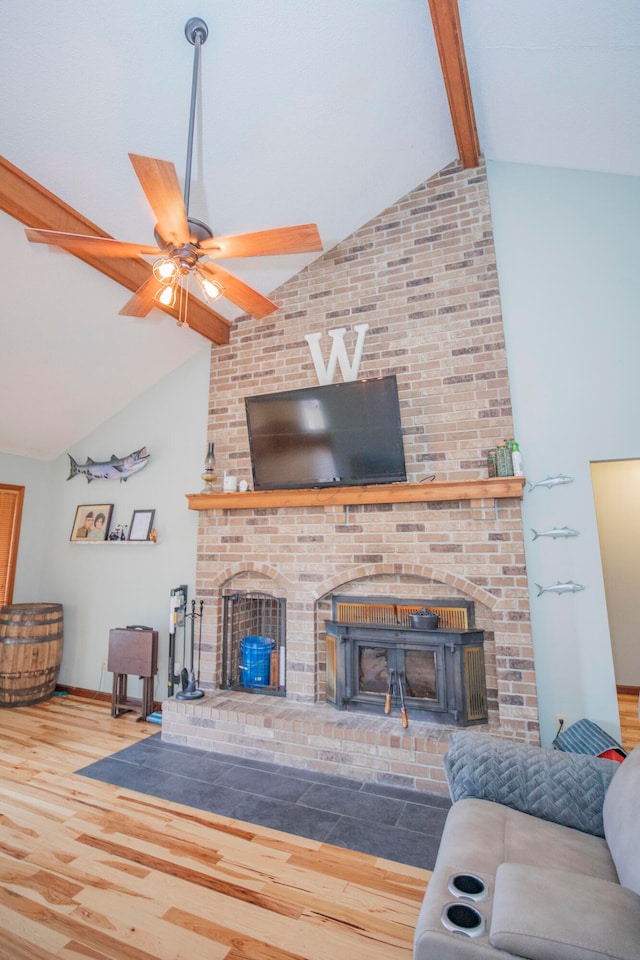 living room featuring a brick fireplace, ceiling fan, beam ceiling, high vaulted ceiling, and hardwood / wood-style flooring