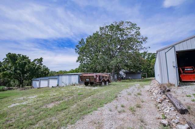 view of yard featuring a garage and an outdoor structure