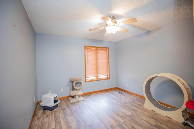 miscellaneous room with a textured ceiling, ceiling fan, and light hardwood / wood-style flooring