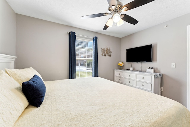 bedroom with ceiling fan and a textured ceiling