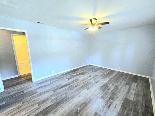 unfurnished room featuring ceiling fan and dark wood-type flooring