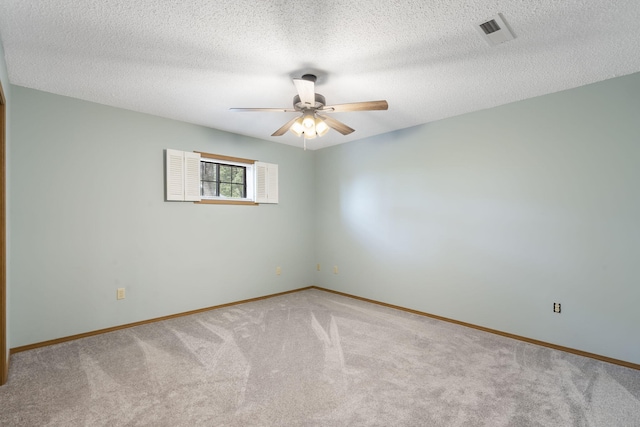 unfurnished room featuring light colored carpet and a textured ceiling