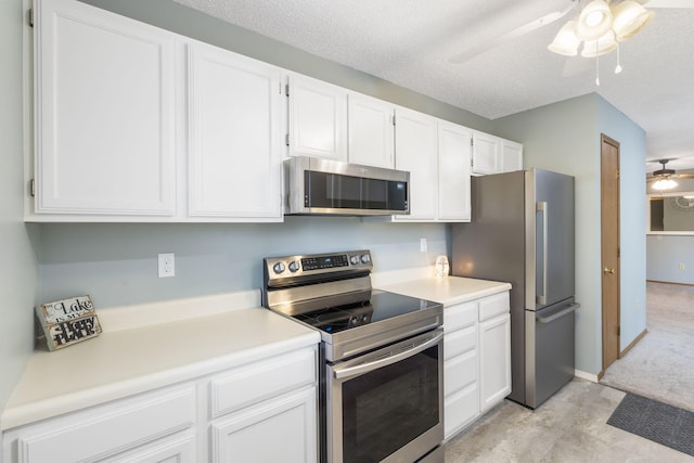 kitchen featuring stainless steel appliances, ceiling fan, white cabinets, and a textured ceiling