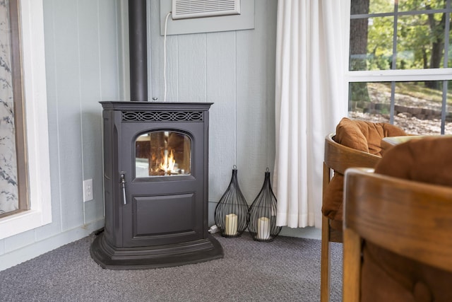 interior details featuring carpet, a wall mounted air conditioner, and a wood stove