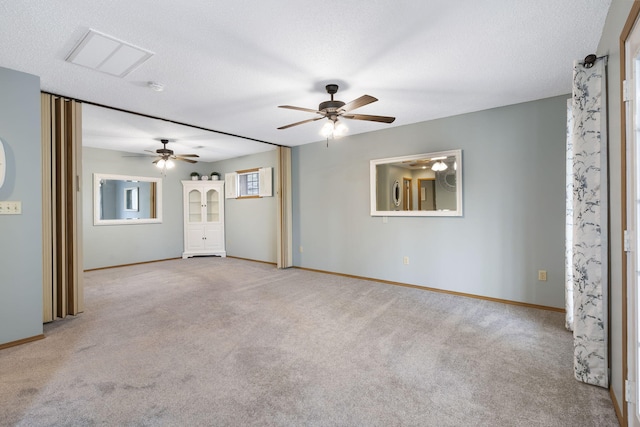 empty room featuring light carpet, a healthy amount of sunlight, ceiling fan, and a textured ceiling