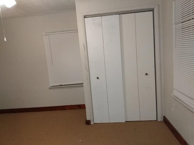unfurnished bedroom with baseboards, carpet floors, and a closet