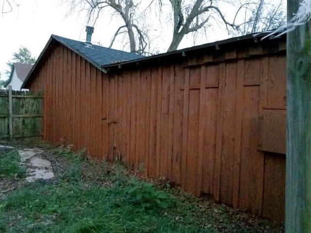 view of outbuilding featuring fence
