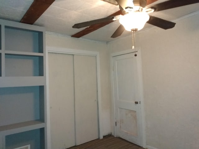 unfurnished bedroom with ceiling fan and a closet