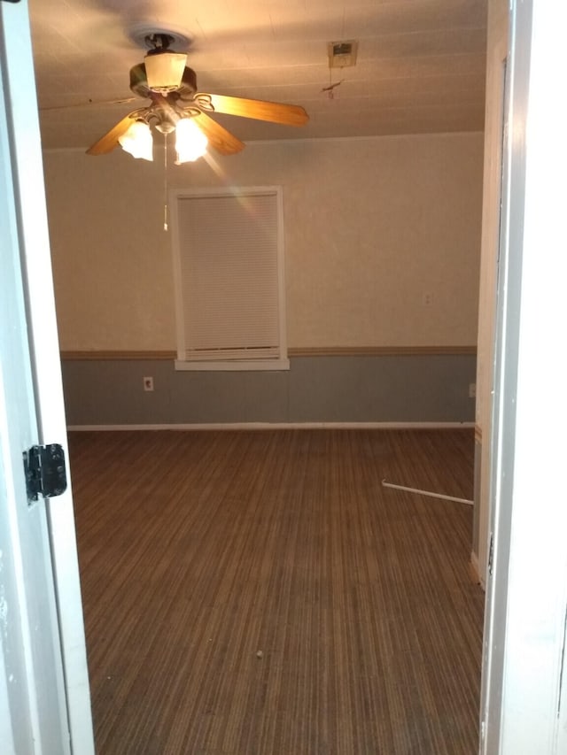 unfurnished room with ceiling fan and dark wood-type flooring