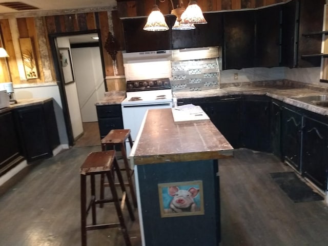 kitchen featuring white electric stove, under cabinet range hood, visible vents, a center island, and dark wood-style flooring