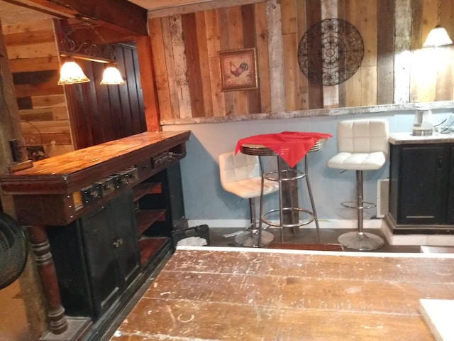 bar with wood walls and decorative light fixtures