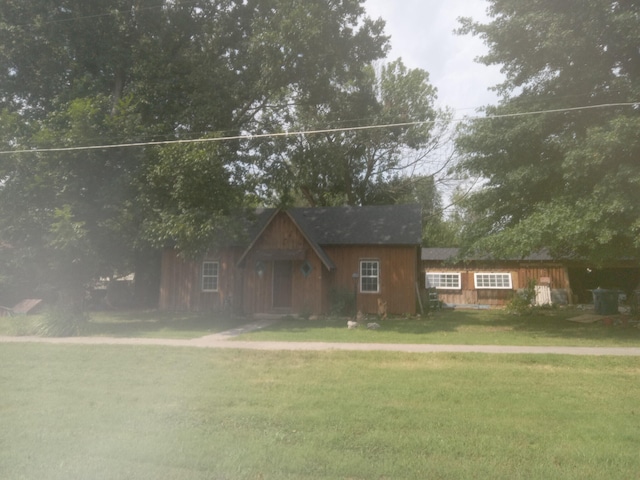 rustic home featuring a front lawn