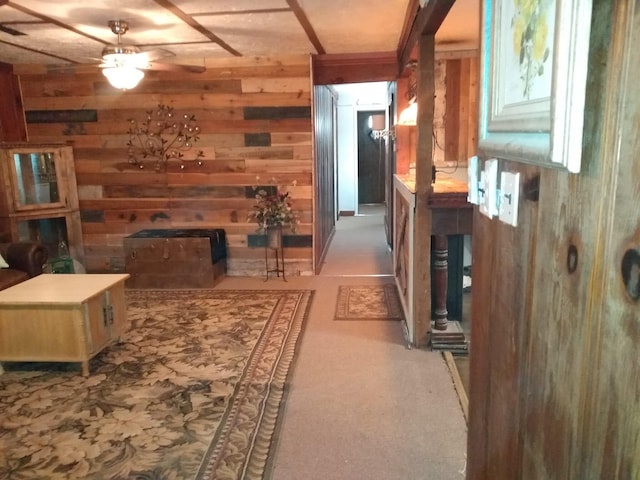 interior space featuring wood walls, light colored carpet, a fireplace, and ceiling fan