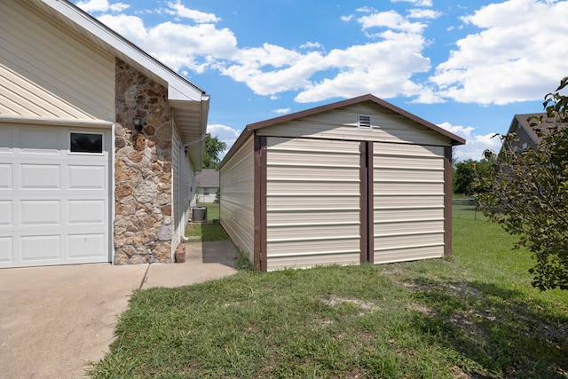 garage featuring a lawn and central air condition unit