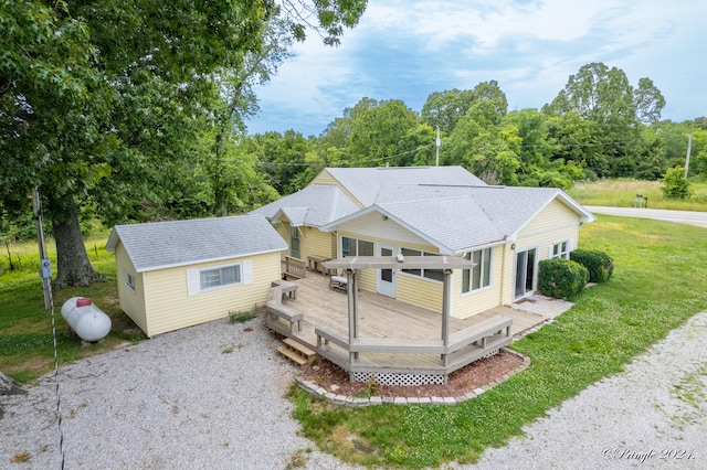 rear view of property with an outdoor structure, a deck, and a yard