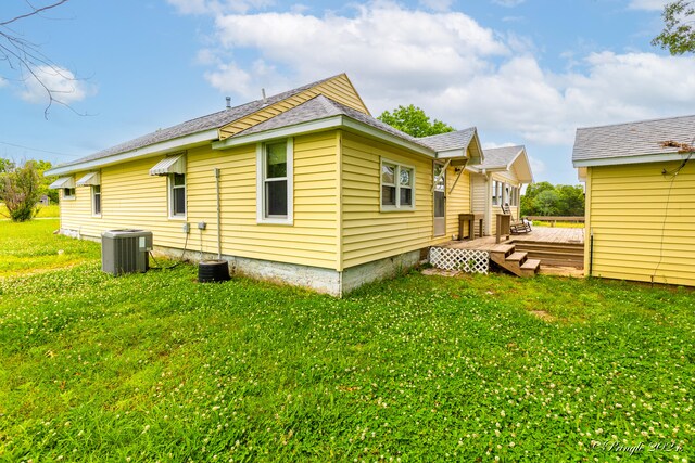 rear view of house featuring a yard, cooling unit, and a deck