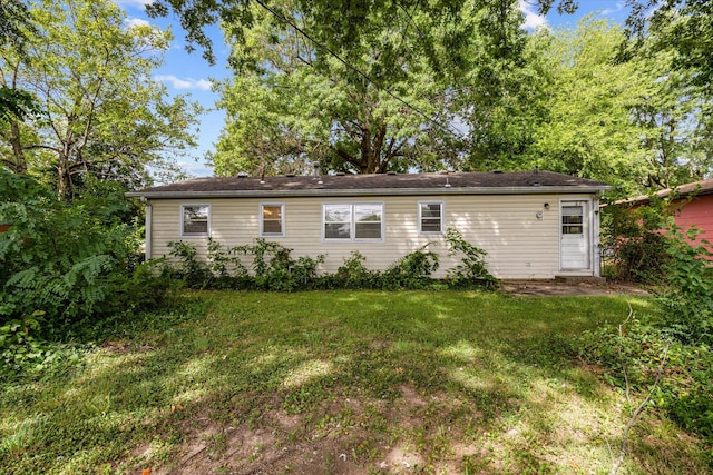 rear view of property with a lawn