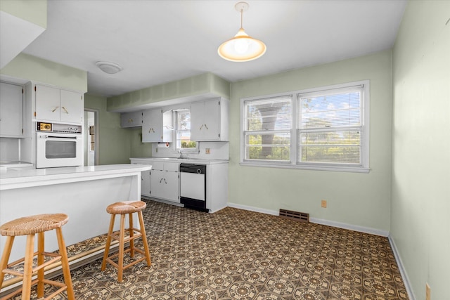 kitchen with sink, a kitchen bar, and white appliances