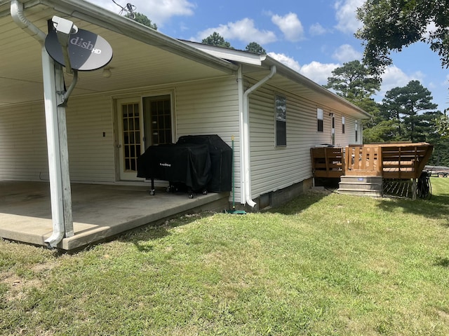 view of property exterior with a lawn and a deck