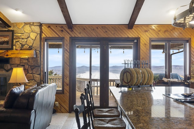 91 Blueview Ln, Kimberling City, MO 65686 - dining space featuring a water and mountain view, wooden walls, beam ceiling, and light tile patterned floors