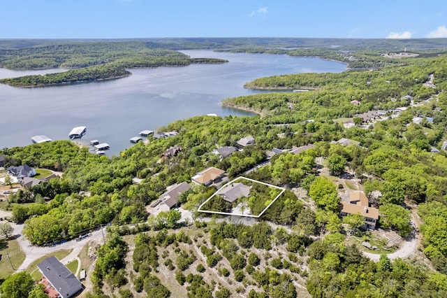 drone / aerial view with a water view and a forest view