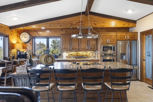 91 Blueview Ln, Kimberling City, MO 65686 - kitchen with stainless steel appliances, dark stone counters, tasteful backsplash, a kitchen bar, and wooden walls