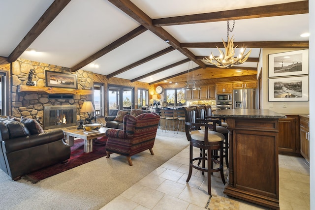 91 Blueview Ln, Kimberling City, MO 65686 - living room featuring wooden walls, light tile patterned floors, lofted ceiling with beams, a fireplace, and a notable chandelier