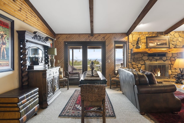 living area with vaulted ceiling with beams, carpet flooring, a fireplace, and wooden walls