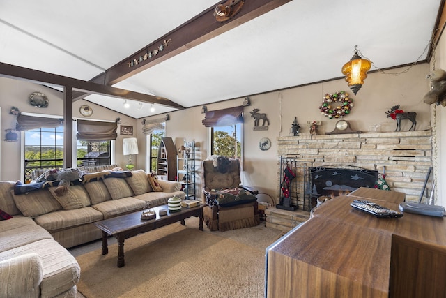 living room with lofted ceiling with beams, a stone fireplace, and carpet flooring