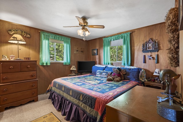 bedroom featuring a ceiling fan, multiple windows, and wooden walls