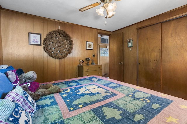 bedroom with ceiling fan, a closet, and wood walls