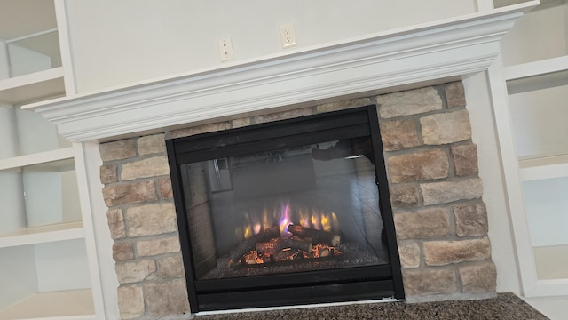 interior details featuring a warm lit fireplace