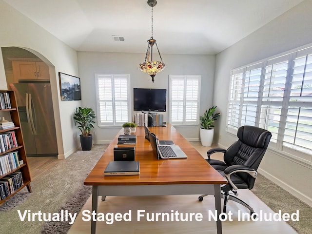 office featuring carpet, arched walkways, visible vents, and baseboards